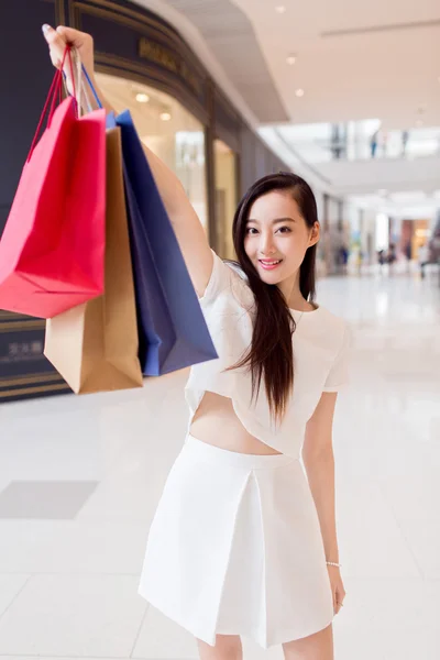 Portrait young adult girl with colored bags — Stock Photo, Image