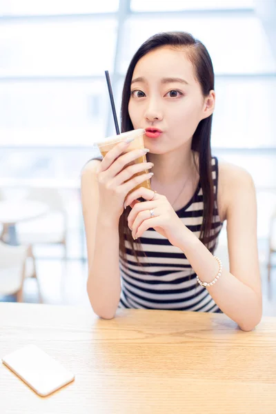 Menina sentada em uma cafeteria — Fotografia de Stock