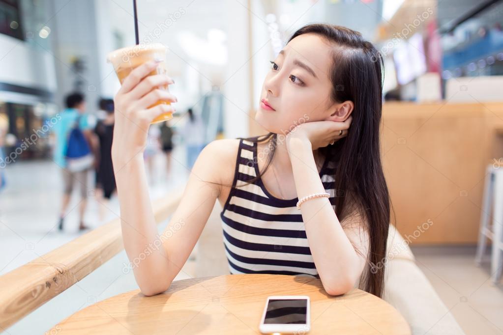 girl drinking a glass of iced drinks