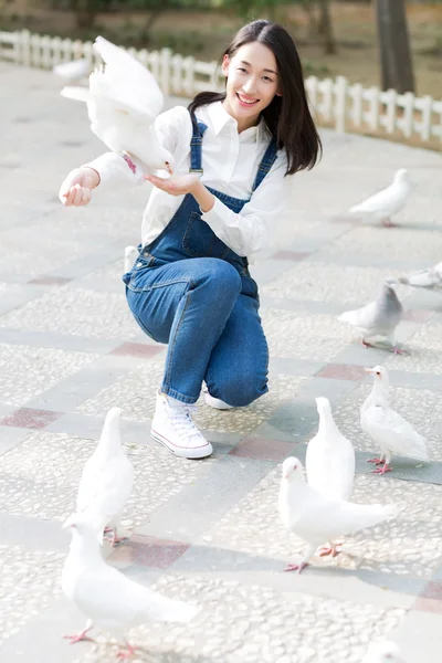 Menina alimentando pombos — Fotografia de Stock