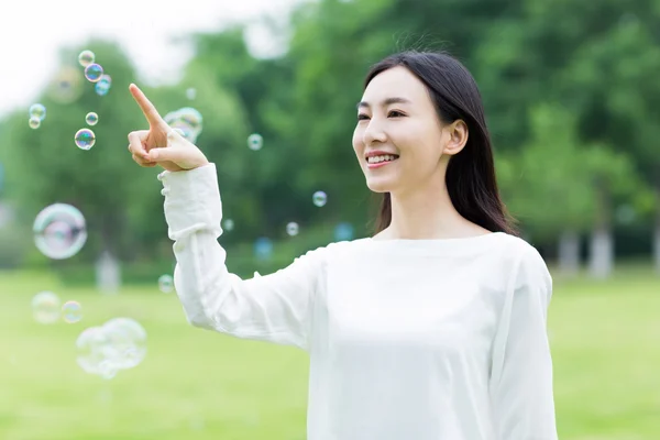 Pretty girl and colorful bubbles — Stock Photo, Image