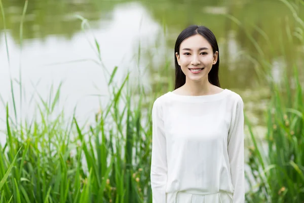 Vrouw in witter jurk zomer temidden van riet — Stockfoto