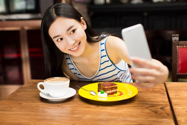 Mädchen im Café schreibt SMS auf Smartphone — Stockfoto