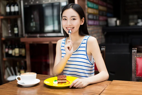 Junge schöne Frau isst ein Dessert — Stockfoto