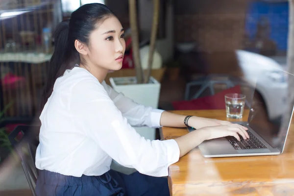 Beautiful hipster woman using laptop at cafe — Stock Photo, Image