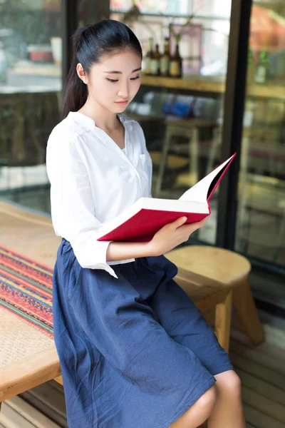 Läser hennes favorit bok i café — Stockfoto