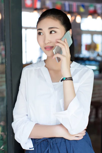 Woman talking on cell phone in a cafe — Stock Photo, Image