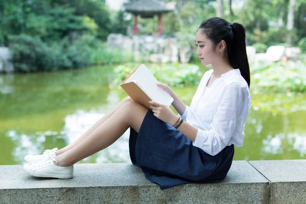 Flickan läsa i parken — Stockfoto