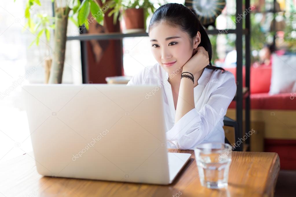beautiful hipster woman using laptop at cafe