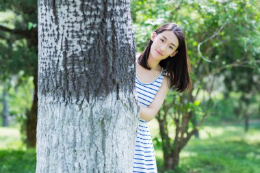 ağaçların arkasına saklanarak kız