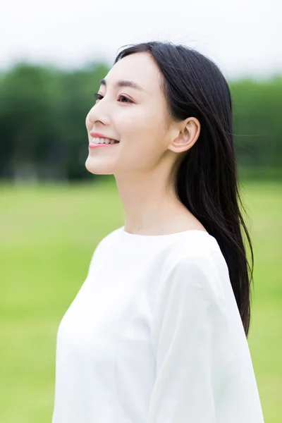 Menina chinesa bonita sorrir no parque — Fotografia de Stock