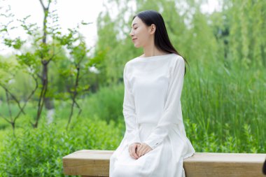 Beyaz bir elbise giyen Çinli kız