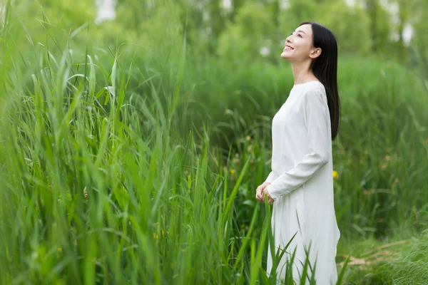 Vrouw in witter jurk zomer temidden van riet — Stockfoto