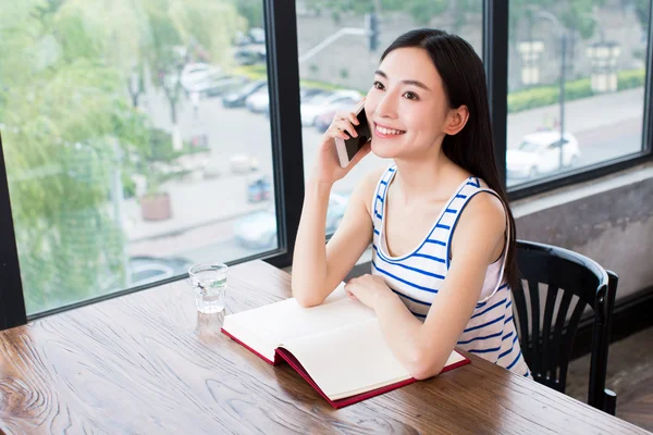 Nő, könyv- és mobiltelefon — Stock Fotó