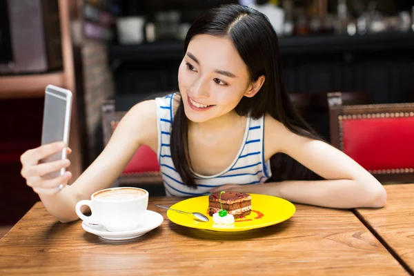 Girl in cafe shop texting on smartphone — Stock Photo, Image