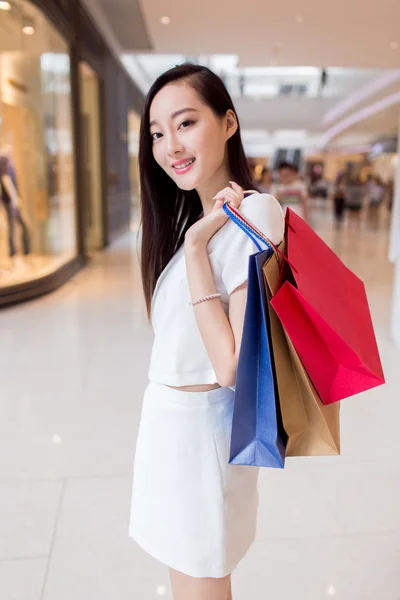 Portrait young adult girl with colored bags — Stock Photo, Image