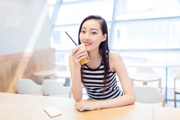 Menina sentada em uma cafeteria — Fotografia de Stock