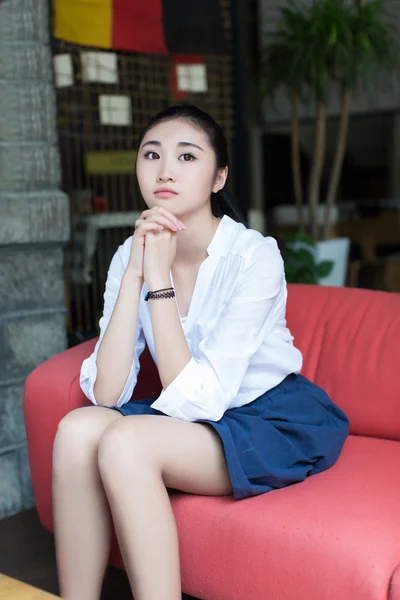 Girl sitting on the sofa — Stock Photo, Image