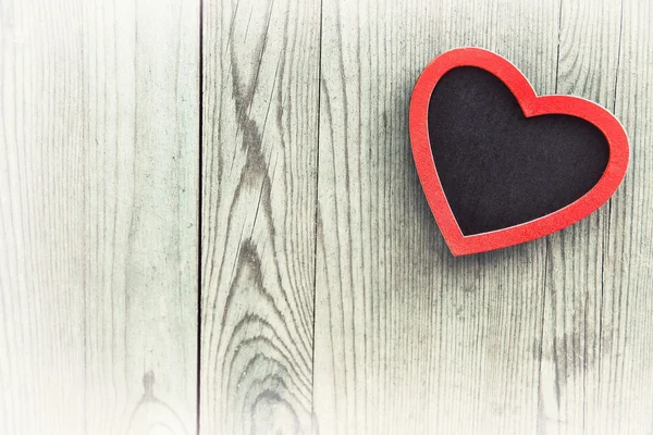 Ahşap arka planda kırmızı kalp.