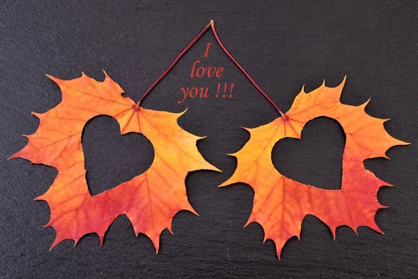 Coração em folhas de outono no fundo de pedra preta — Fotografia de Stock