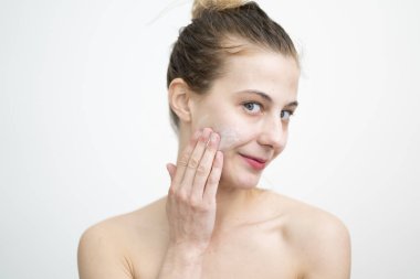 Mutlu Genç Kadın Yüzüne Krem Sürerken, Stüdyo Çekimi Beyaz Arkaplanda