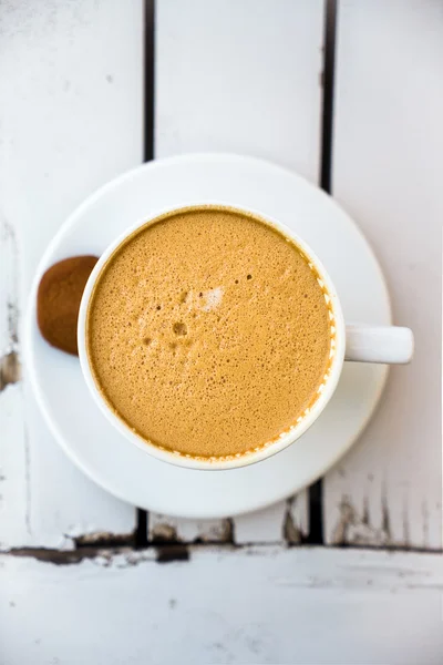 Cup of hot coffee with cookie on old white table — Stock Photo, Image