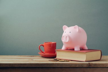 Kahve fincanı ve kitap ile Piggy banka