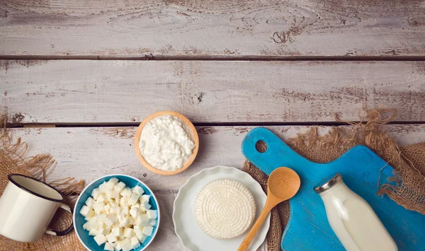 Formaggio su piatti e bottiglia di latte — Foto Stock