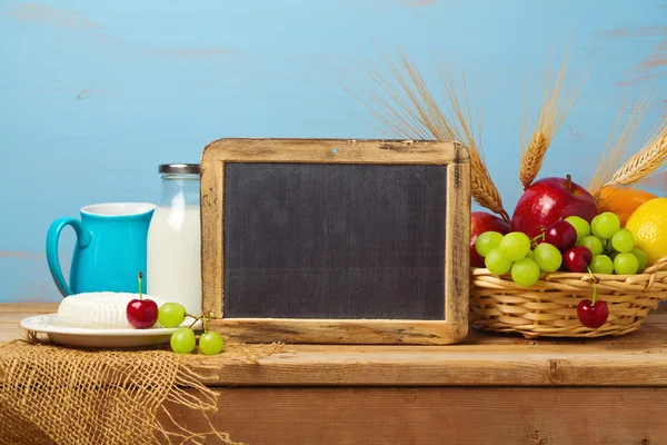 Chalkboard with fruit basket and milk — Stock Photo, Image