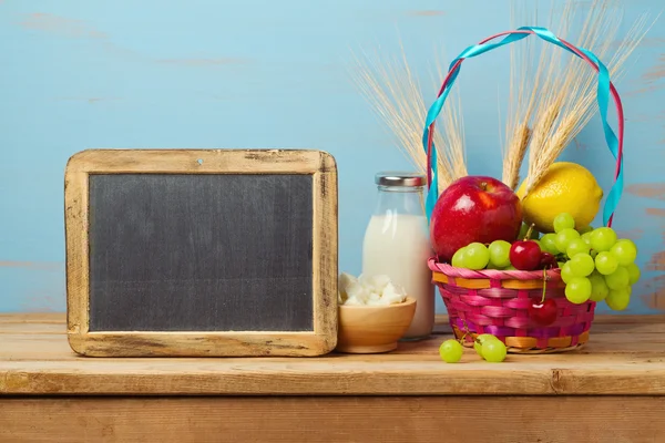Молоко и фрукты корзина на столе — стоковое фото