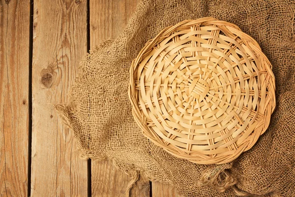 Cesta de mimbre vacía sobre tela de saco — Foto de Stock