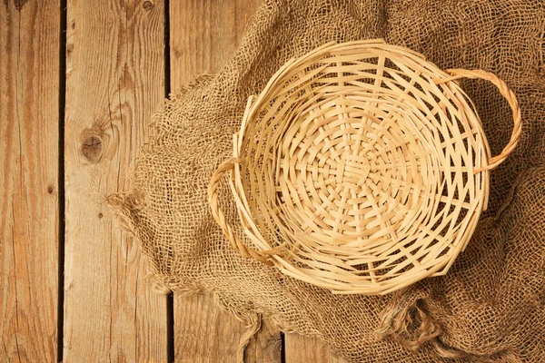 Empty wicker basket on sackcloth — Stock Photo, Image
