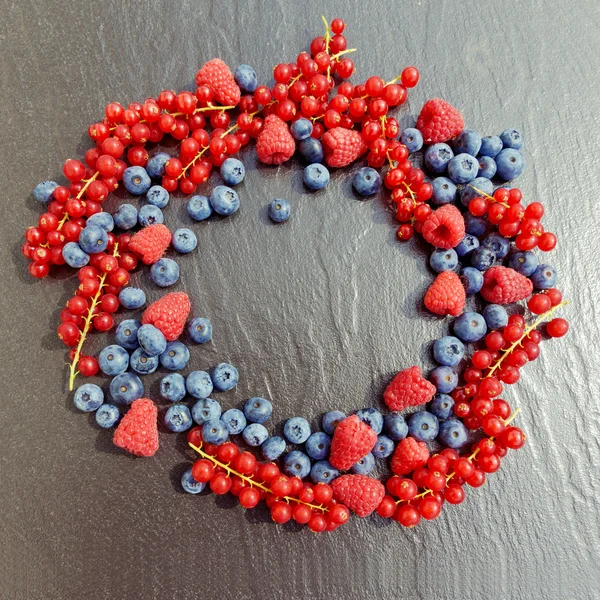 Organic berries on black table — Stock Photo, Image