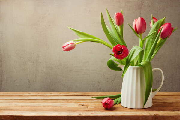 Tulips in vase on wooden table