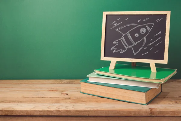 Books, chalkboard and rocket sketch — Stock Photo, Image