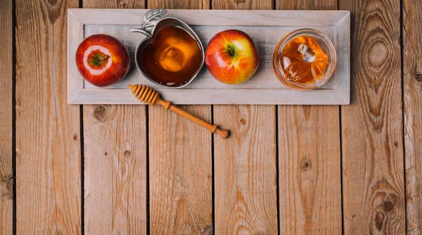 Мед и яблоки на деревянном столе — стоковое фото