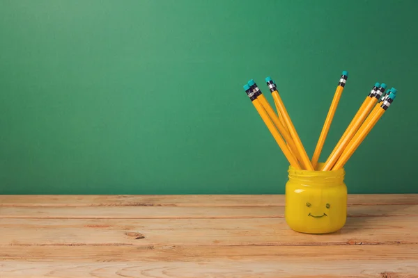 Ahşap masa üzerinde emoji kavanoza kalemler — Stok fotoğraf