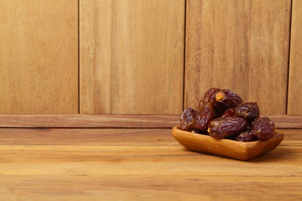 Dates on wooden plate — Stock Photo, Image