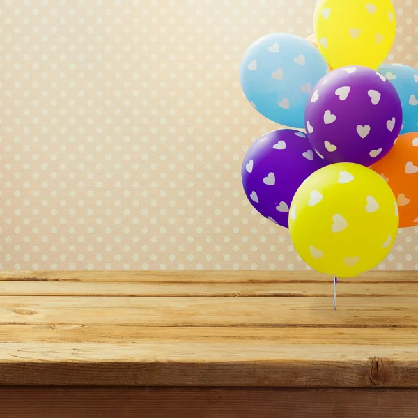 Empty wooden table and balloons — Stock Photo, Image