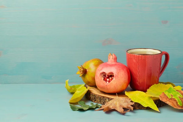 Kopje thee, granaatappel en bladeren — Stockfoto