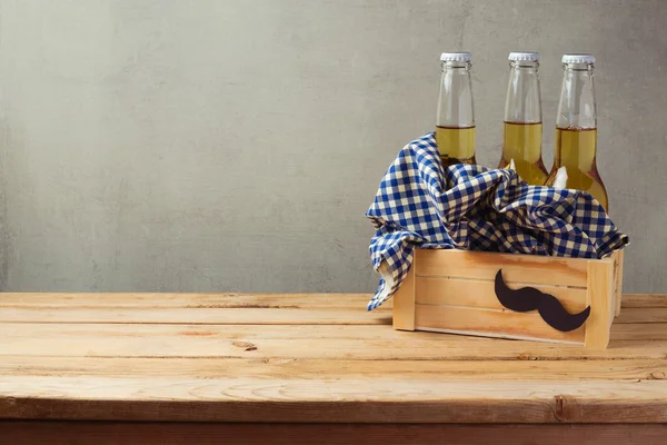 Beer bottles in box on wooden table — Stock Photo, Image