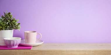 Mutfak arka planında kahve fincanı, kase ve ağaç rafları var.