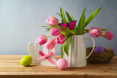Paskalya bayramı konsepti. Paskalya yumurtaları ve lale çiçekleri ahşap masada.