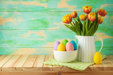 Paskalya bayramı konsepti. Paskalya yumurtaları ve lale çiçekleri ahşap masada.