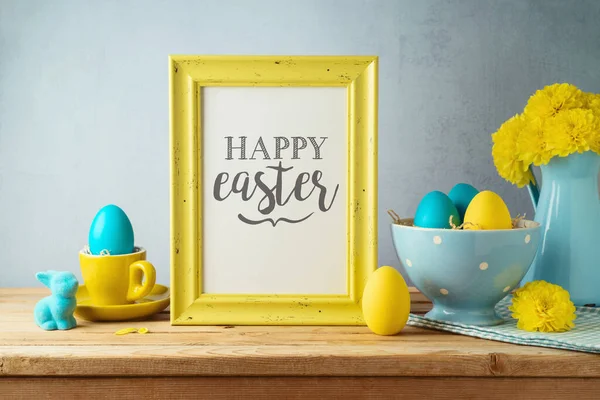 Easter holiday photo frame mock up with Easter eggs, flowers and bunny decoration on wooden table