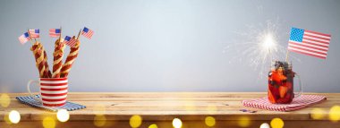 Bağımsızlık Günü 'nüz kutlu olsun. 4 Temmuz kutlamaları. Yaz mevsimi taze meyve suyu, sosisli sandviç ve ahşap masada Amerikan bayrağı.