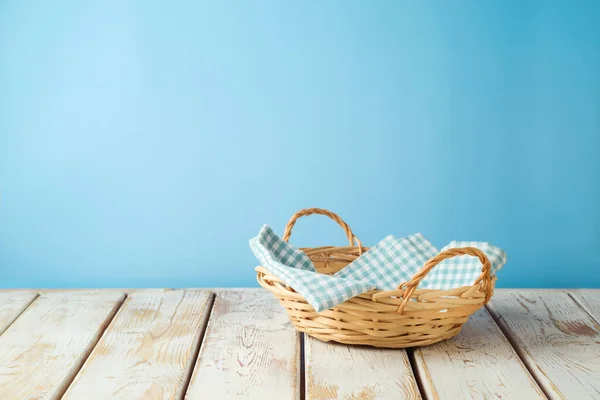 空柳条筐 桌布铺在蓝墙背景的乡村桌子上 厨房模拟设计和产品展示 — 图库照片