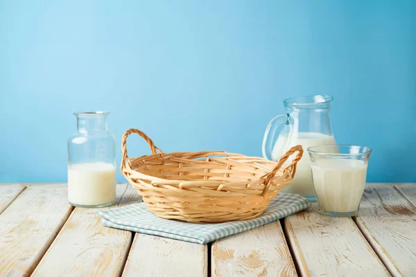 Empty Wicker Basket Tablecloth Milk Bottles Rustic Table Blue Wall — Stock Photo, Image