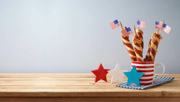 ハッピー インデペンデンス 7月4日のお祝いのコンセプト ツイストホットドッグソーセージと木製のテーブルの上のアメリカ国旗 — ストック写真