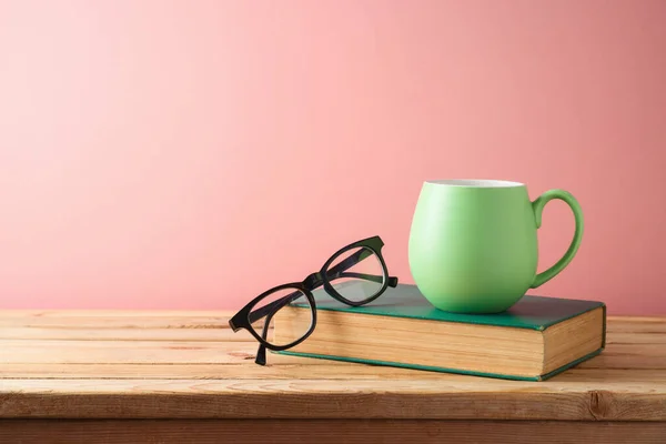 Grön Kaffekopp Glasögon Och Boka Träbord Över Rosa Bakgrund Tillbaka — Stockfoto